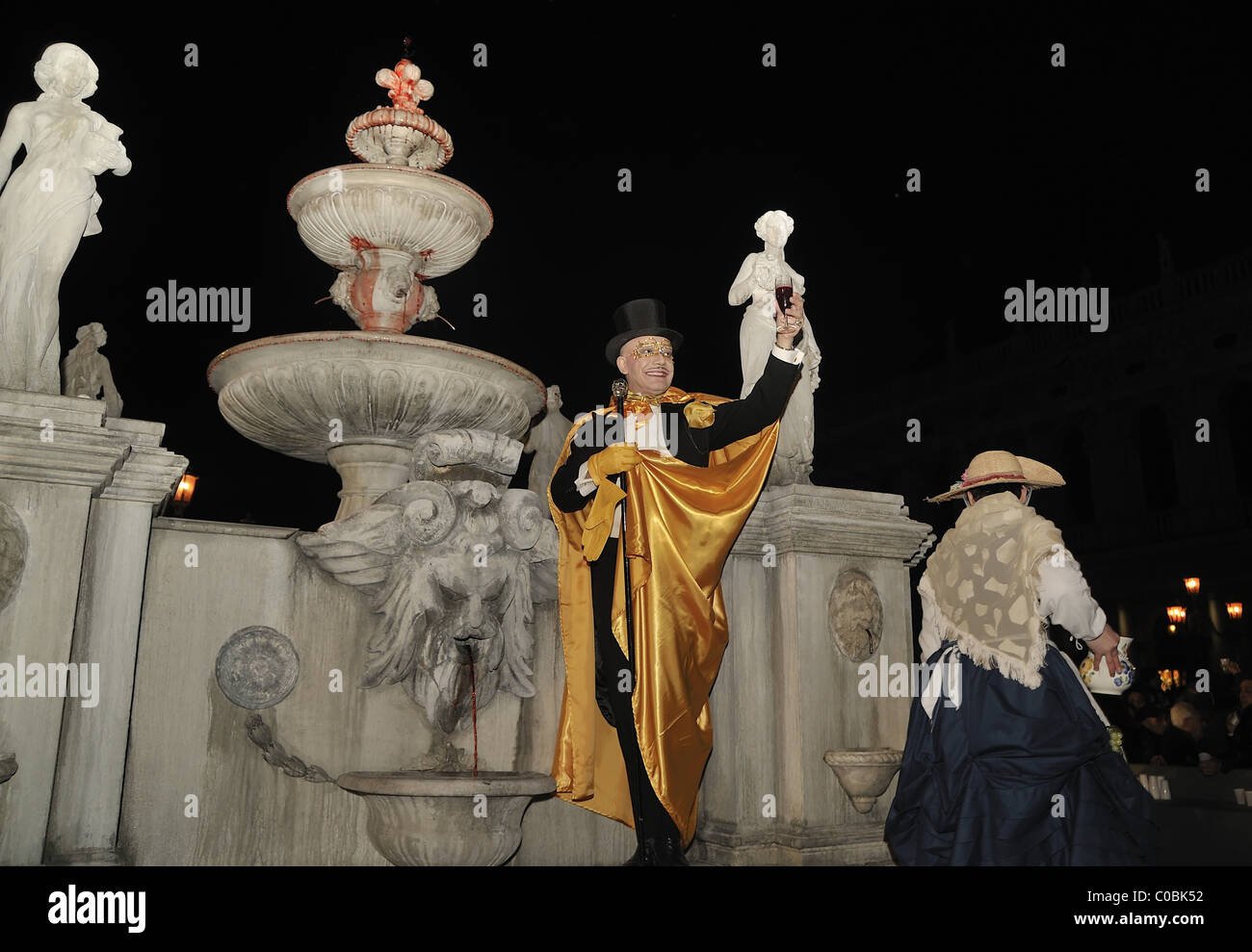 DJ Prince Miichael, toasts to the crowd by the wine fountain in St Mark Square Stock Photo
