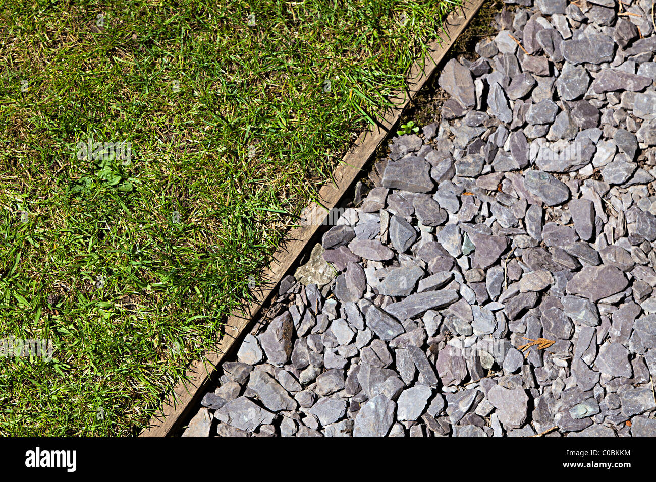 Stones used to make path alongside lawn in garden Wales UK Stock Photo