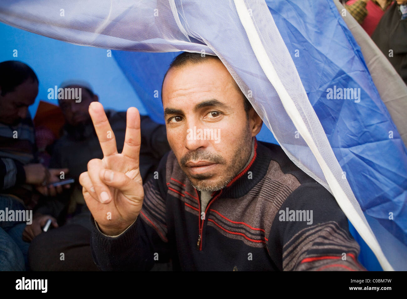 A man in a tent gives the peace sign in Tahrir Square hours before President Mubarak steps down from office on Feb.11, 2011 Stock Photo