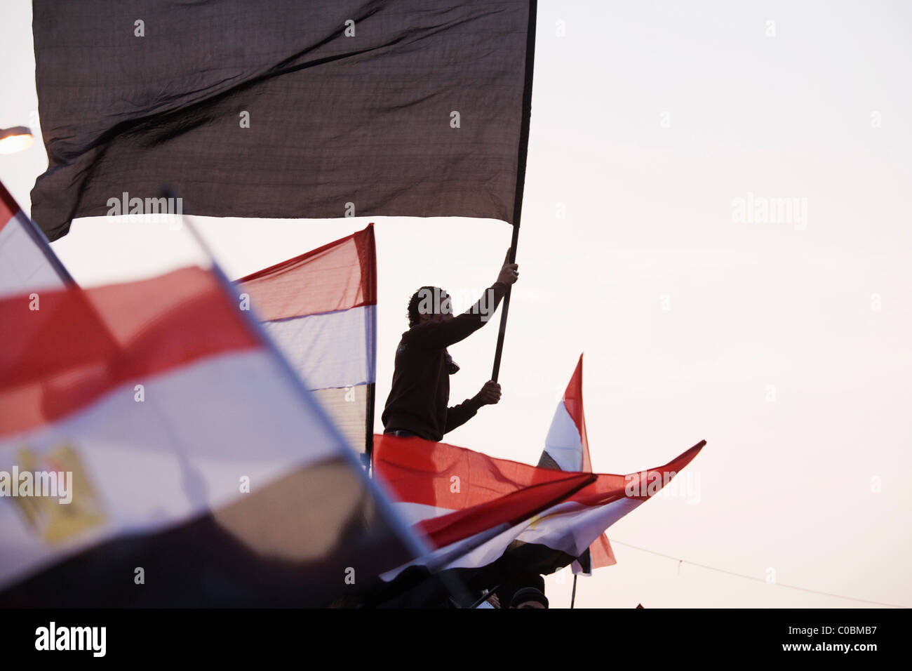 A  man waves an Egyptian flag in Tahrir Square hours before President Hosni Mubarak steps down from office on Feb.11, 2011 Stock Photo