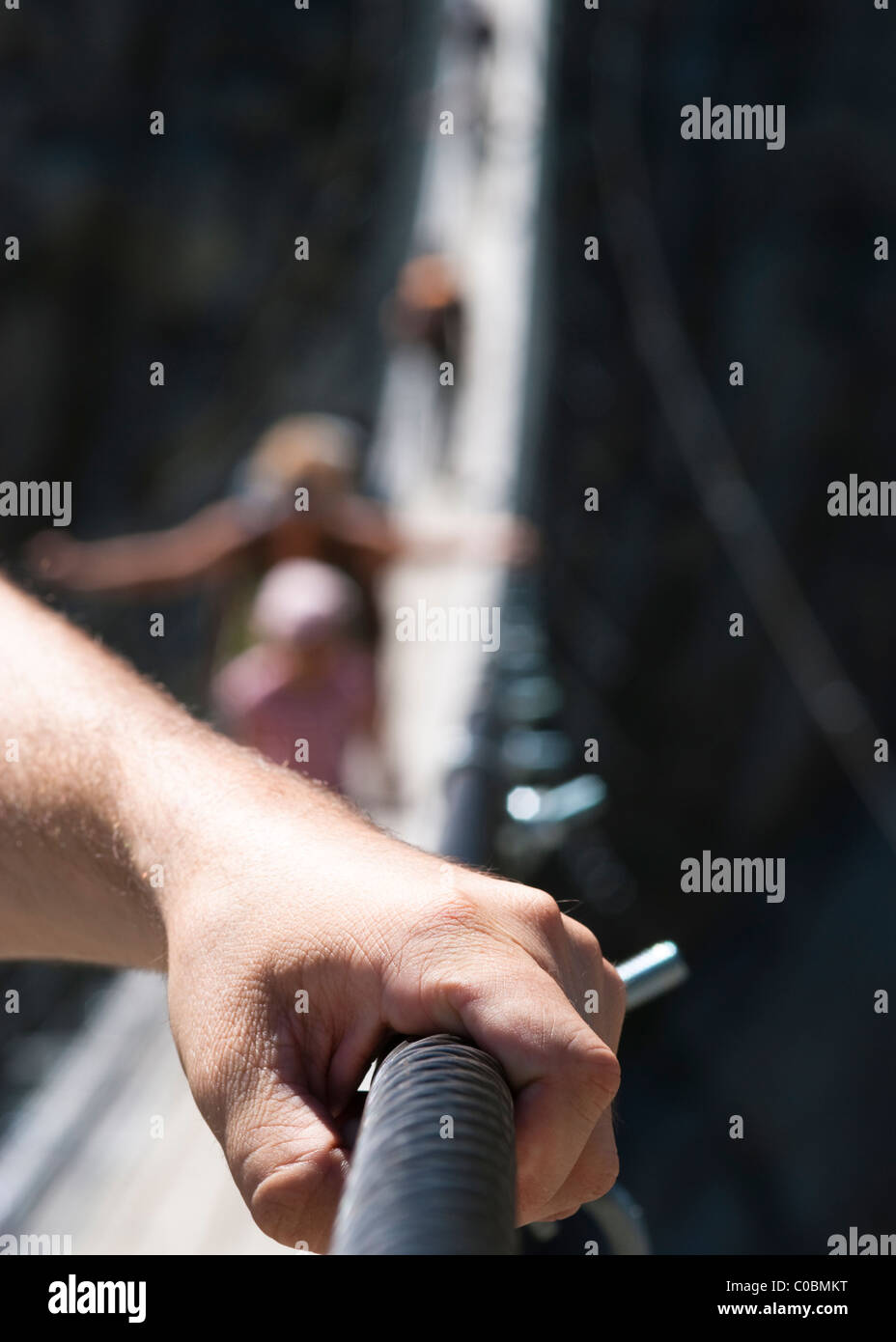 Man holding onto railing on rope bridge Stock Photo Alamy