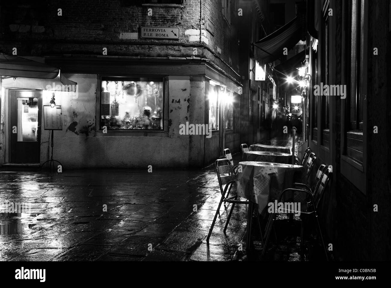 View of an empty outdoor café at night, B&W Stock Photo