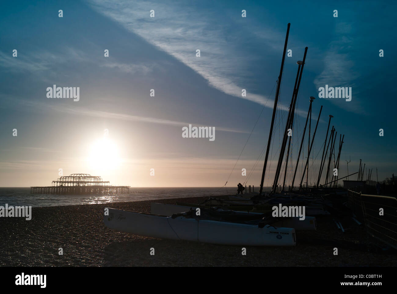 Brighton Beach at Sunset, UK, with Couple Kissing in the Distance. Stock Photo