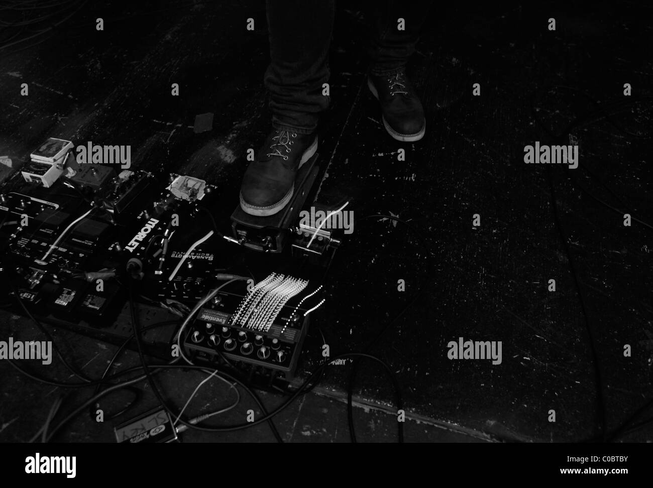 Randy Randall adjusts foot pedals for his guitar. NO AGE at Rhinos in ...