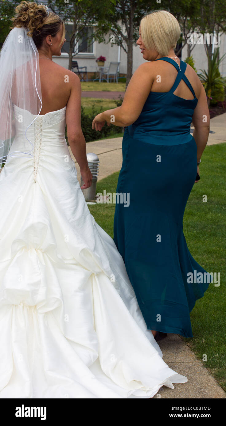 JUST MARRIED BRIDE WALKING AND TALKING TO A GUEST AT HER WEDDING Stock Photo