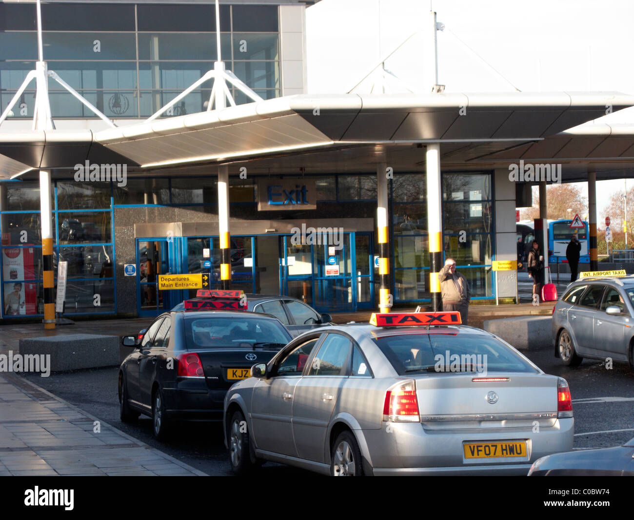 taxis queue at the exit of Belfast International Airport Northern Ireland Stock Photo