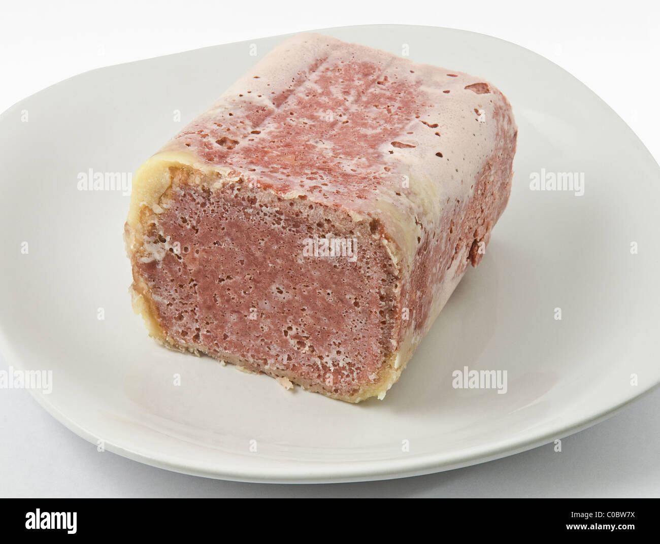 Corned beef on a white plate ready for cutting Stock Photo