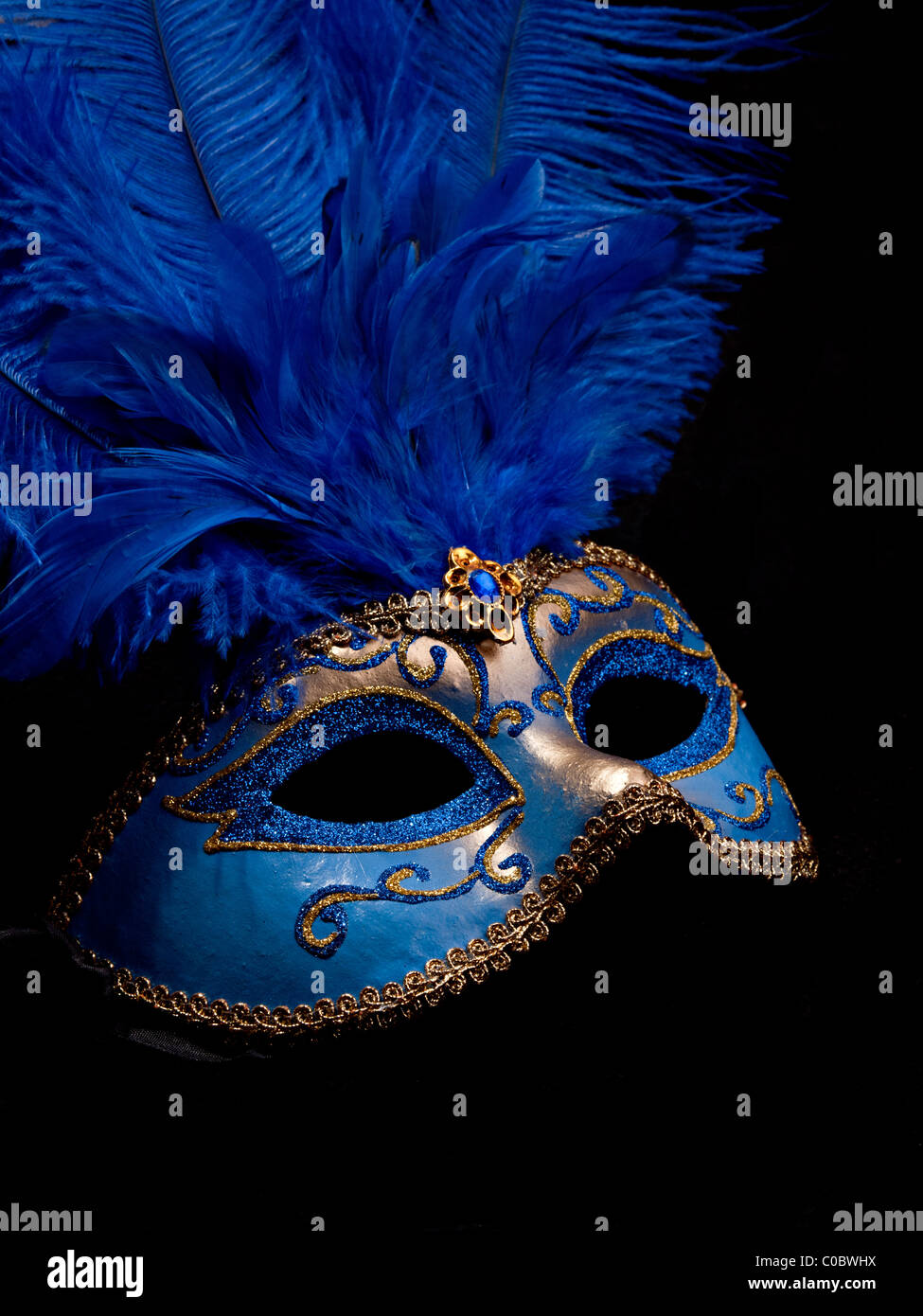 A blue masquerade mask on black background Stock Photo - Alamy