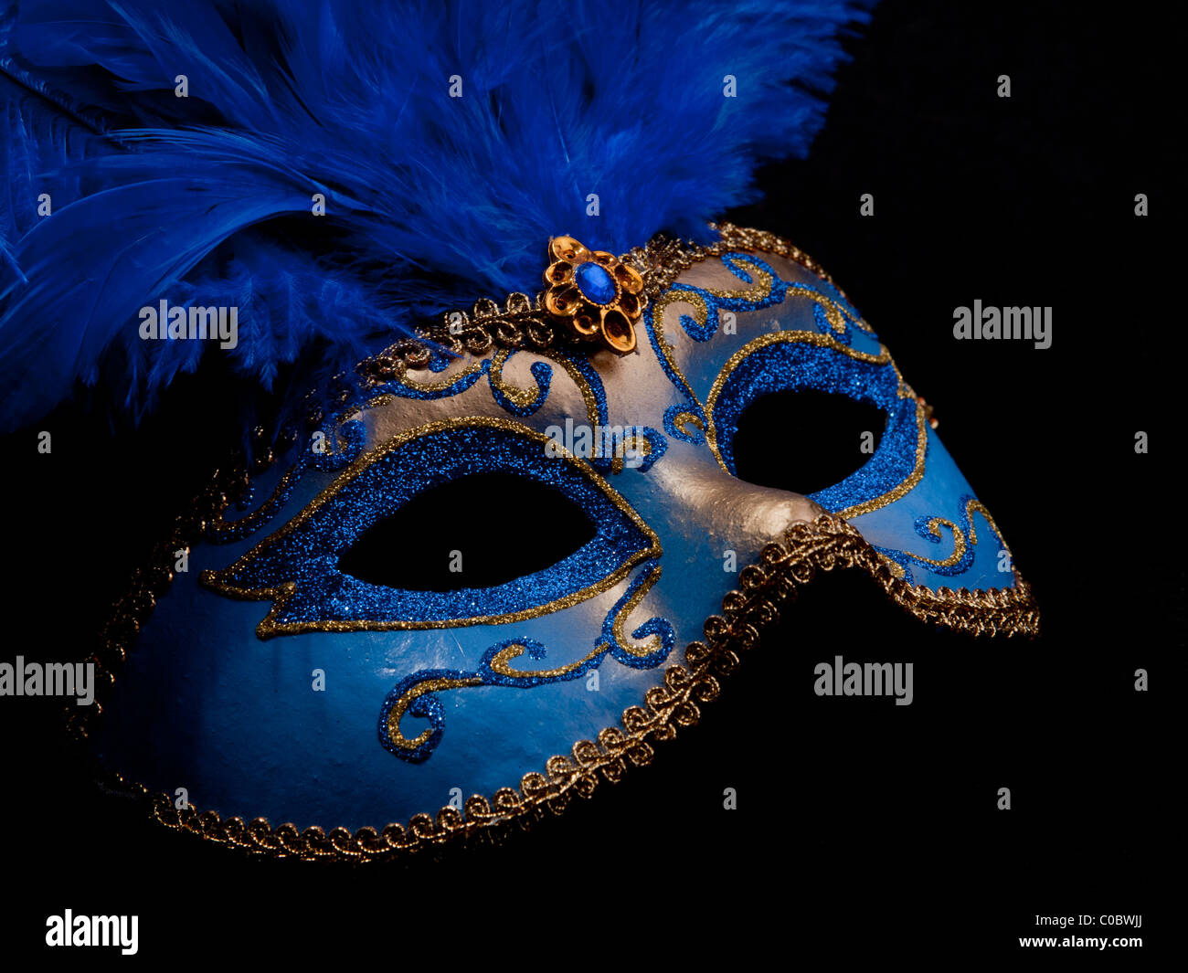 A blue masquerade mask on black background Stock Photo - Alamy