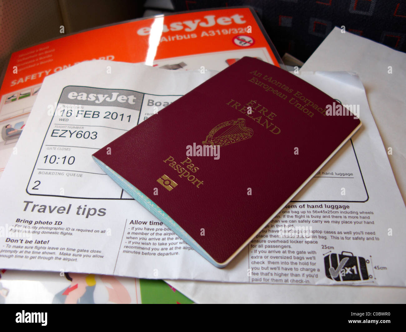 irish passport printed boarding card and safety on board aircraft card on a flight out of ireland Stock Photo