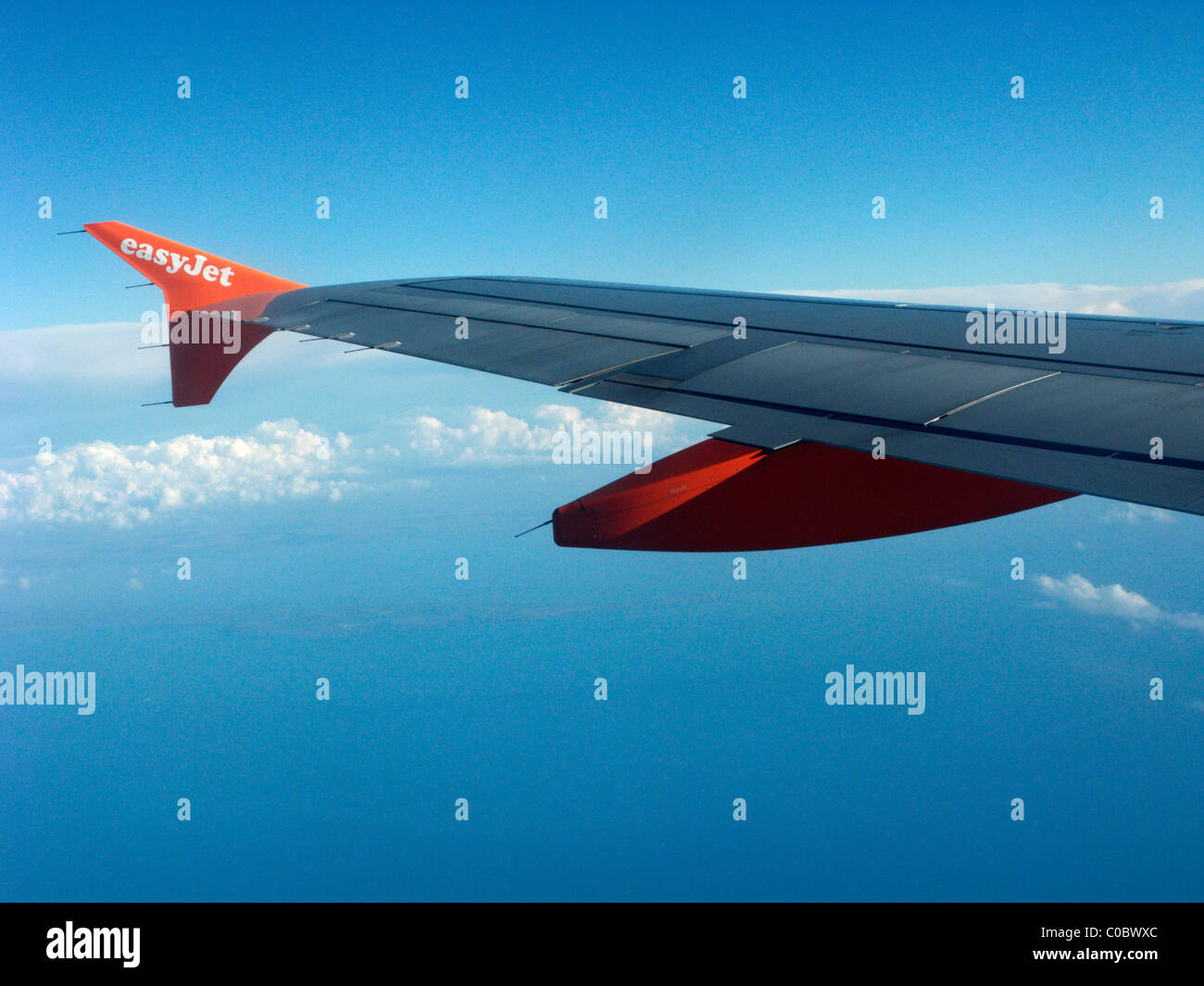 easyjet a319 airbus aircraft wing looking out through aircraft window showing ailerons and flaps Stock Photo