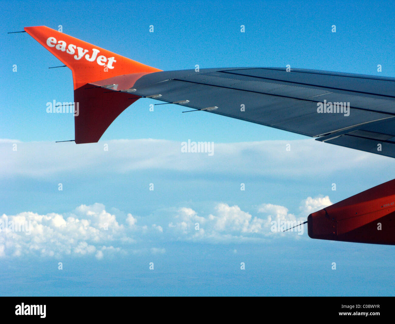 easyjet a319 airbus aircraft wing looking out through aircraft window showing ailerons and wingtip fence Stock Photo