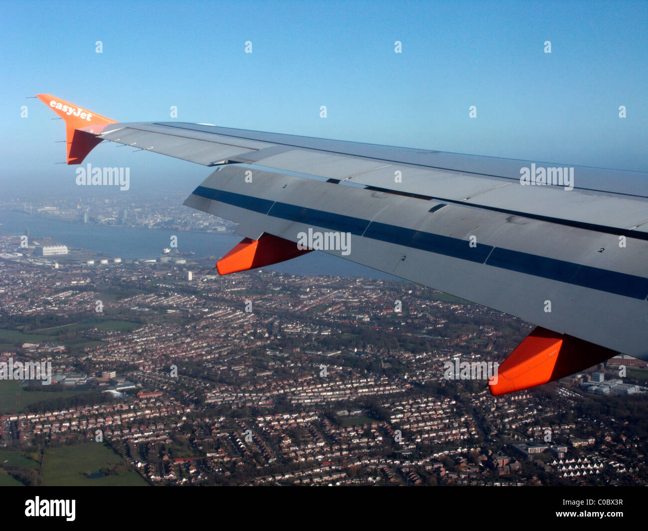 easyjet a319 airbus aircraft wing looking out through aircraft window down at birkenhead and liverpool Stock Photo