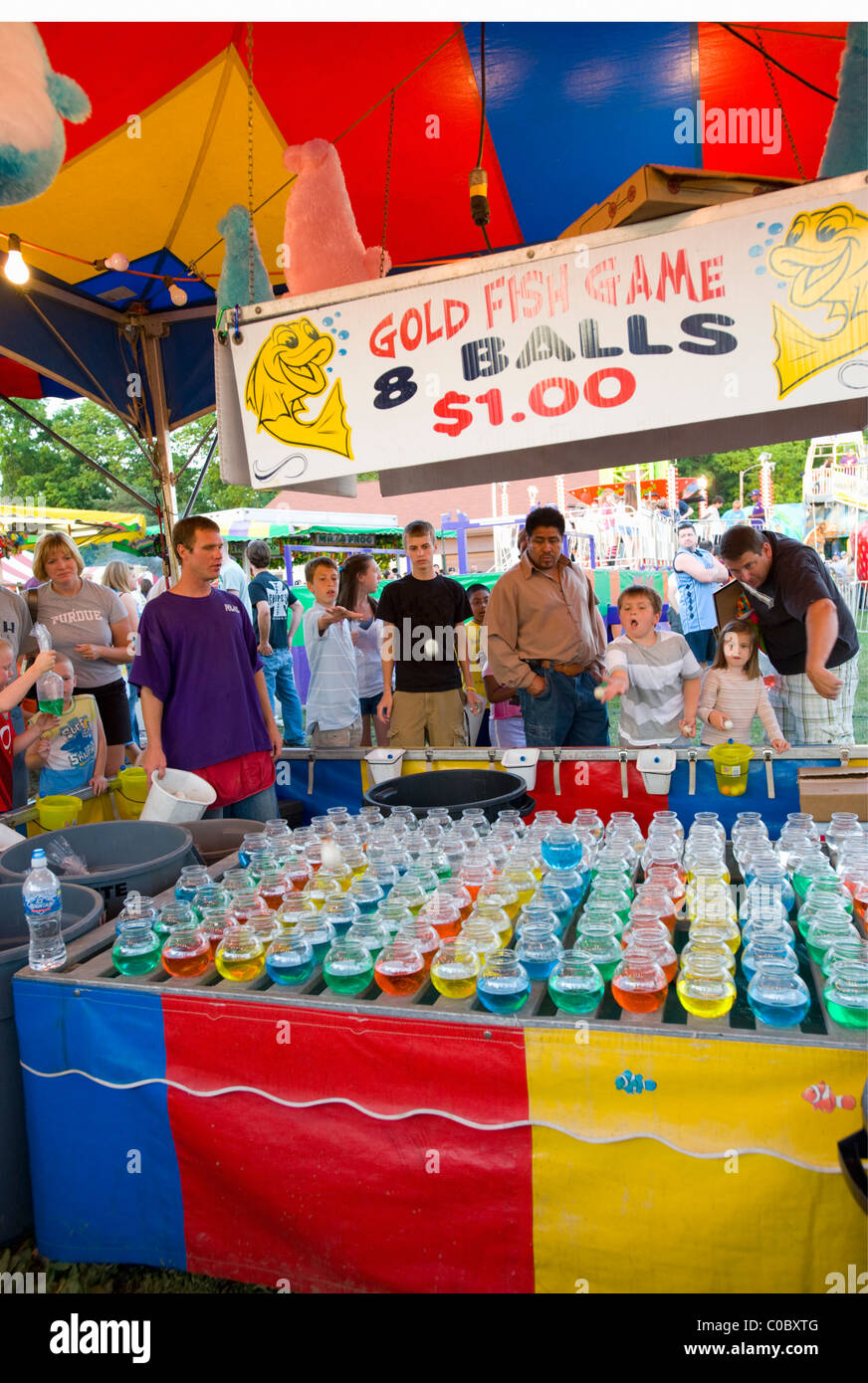 Children trying to win goldfish at local county fair in Indiana. Ping pong balls are bounced
