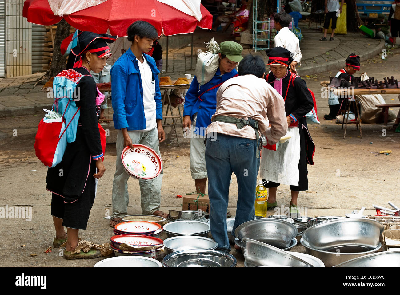 Asia, China, Yunnan, Honghe Prefecture, Jinping County, Nafa Town. Indigo Yao people shop for a wash pan on market day. Stock Photo