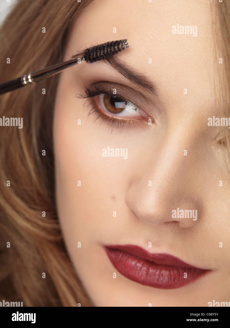 License available at MaximImages.com - Closeup of a woman's face with makeup being applied to her eyebrows Stock Photo