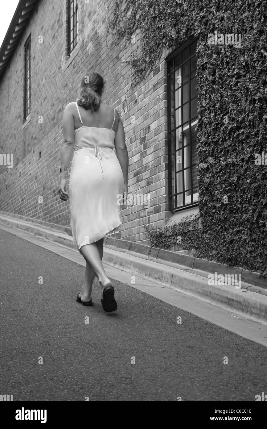 Young woman walking up a street in the Rocks area of Sydney, NSW, Australia Stock Photo