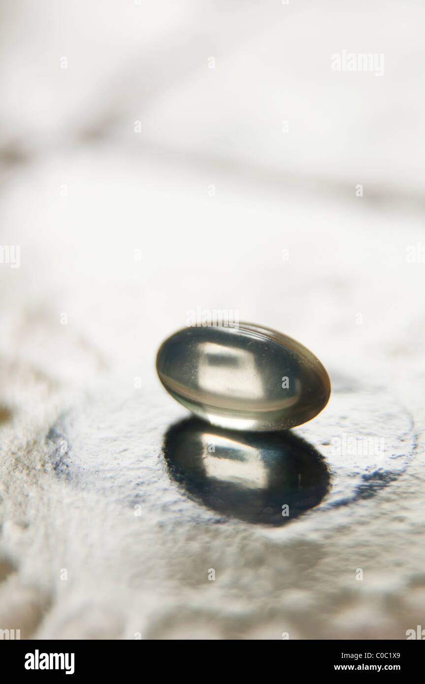 Vitamin E capsule on tile countertop Stock Photo