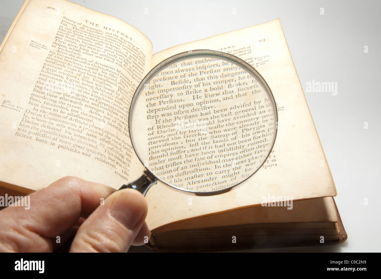Magnifying glass searching old text Stock Photo