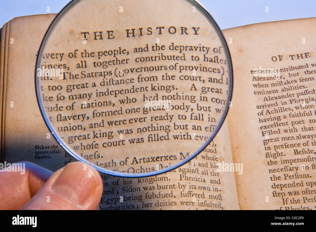 Magnifying glass searching old text Stock Photo