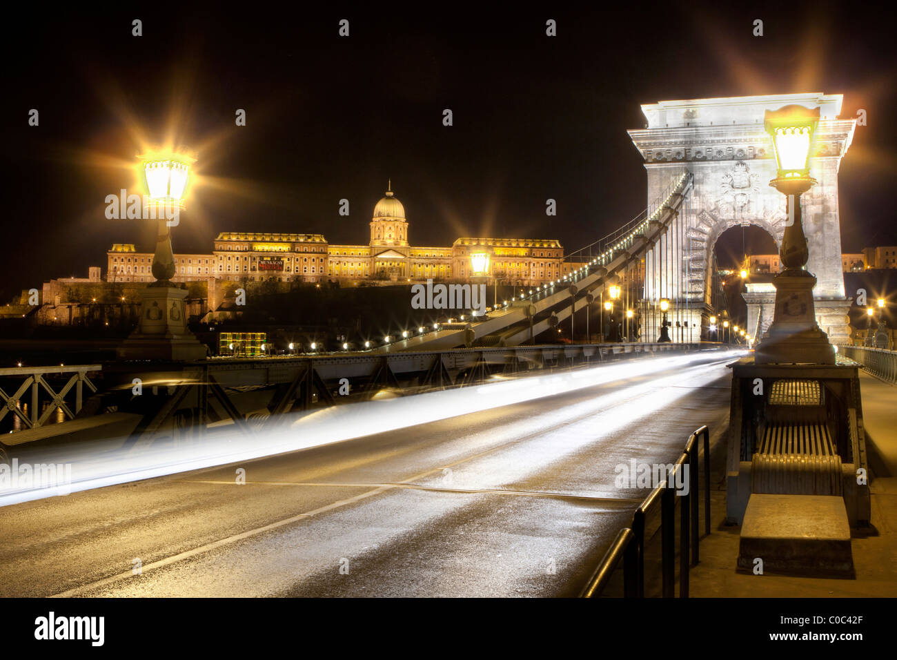 Chain Bridge at night in Budapest with The Royal Palace/Buda Castle in the background Stock Photo