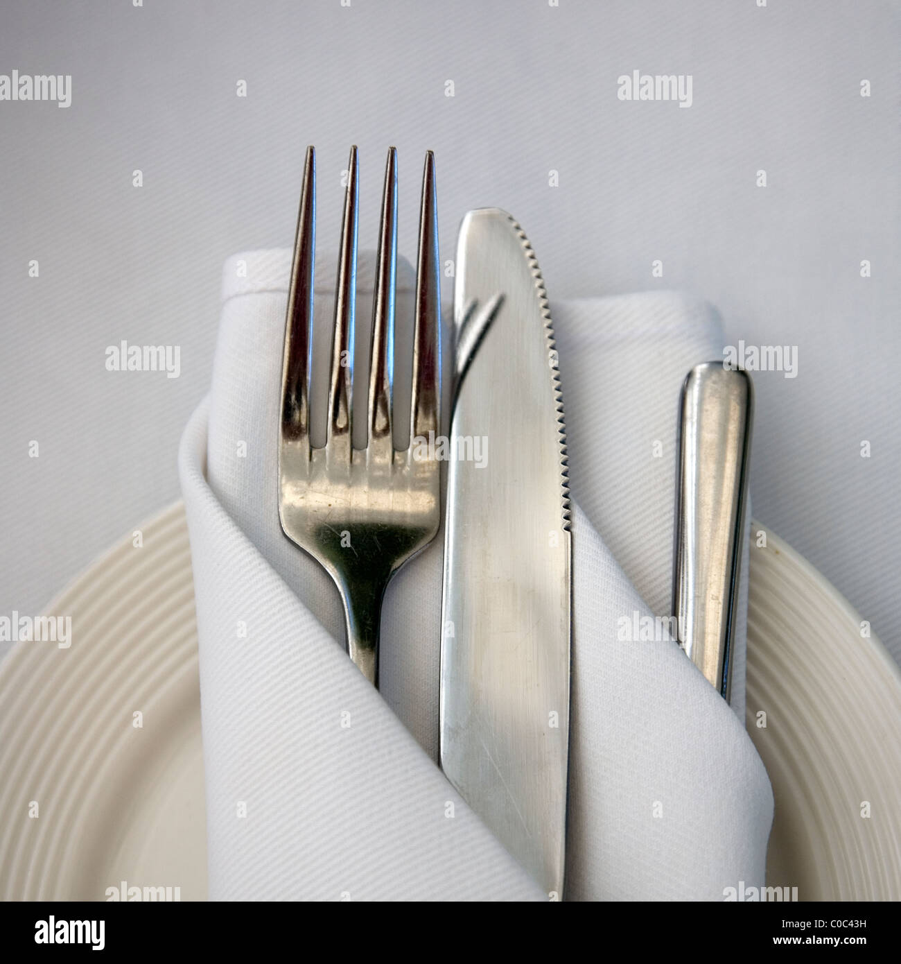 Table setting of Cutlery wrapped in cloth napkin on plate Stock ... Table setting of Cutlery wrapped in cloth napkin on plate Stock ...