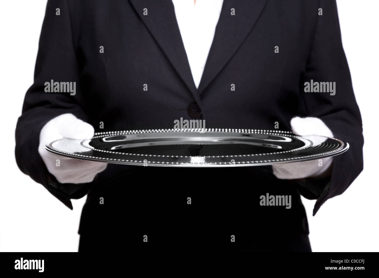 Photo of an unrecognizable female butler holding a silver tray, isolated against a white background. Stock Photo