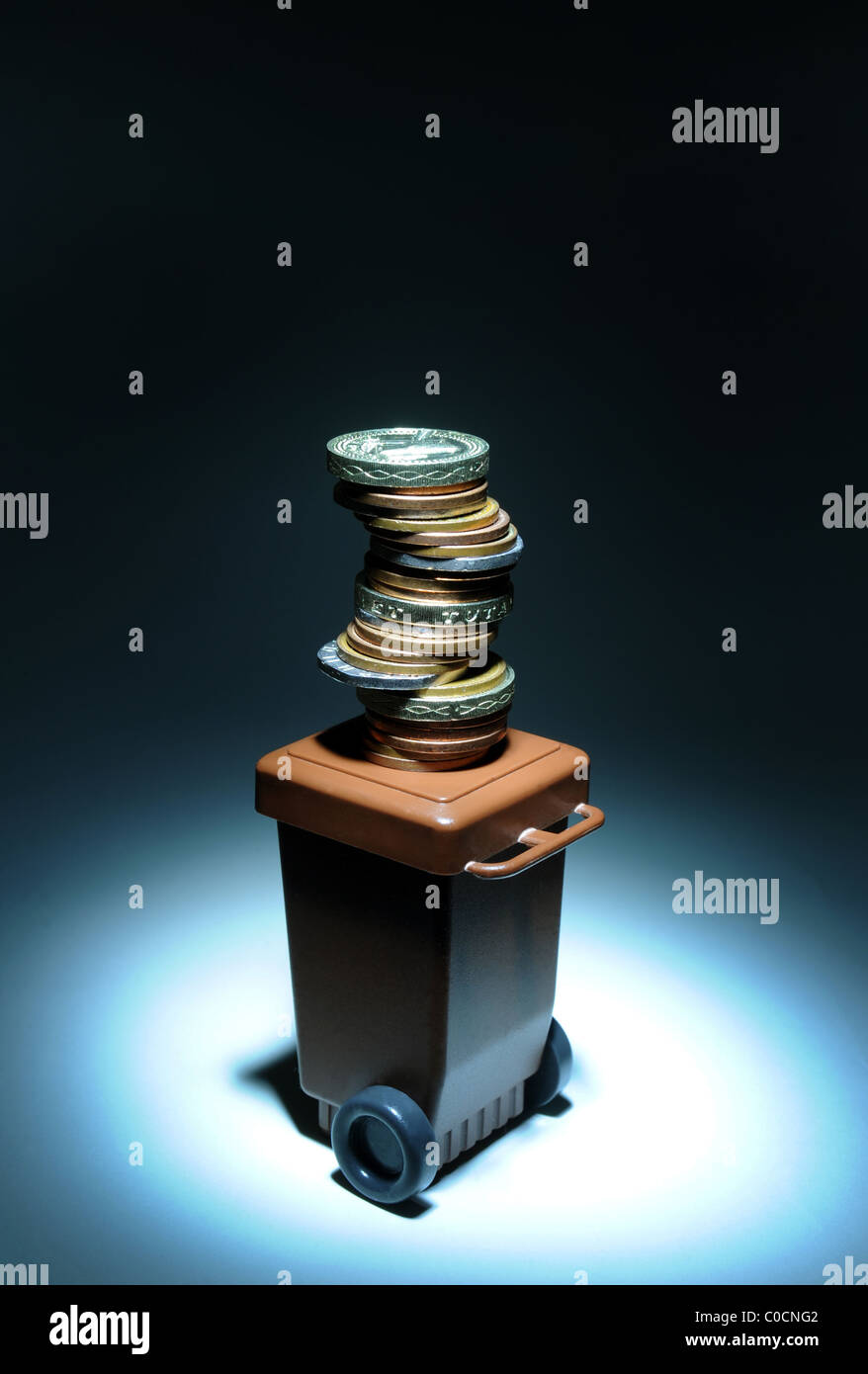RUBBISH DOMESTIC WASTE WHEELY  WHEELIE BIN WITH MONEY RE COSTS OF RECYCLING GARBAGE  ENVIRONMENT RECYCLE  BIN MEN COLLECTIONS UK Stock Photo