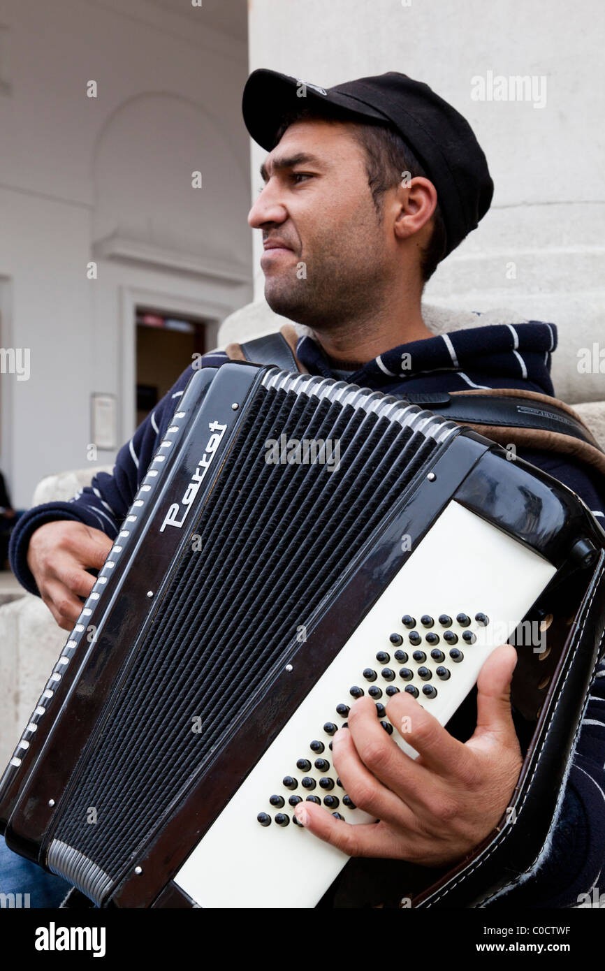 A busker plays an accordion in the street Stock Photo Alamy