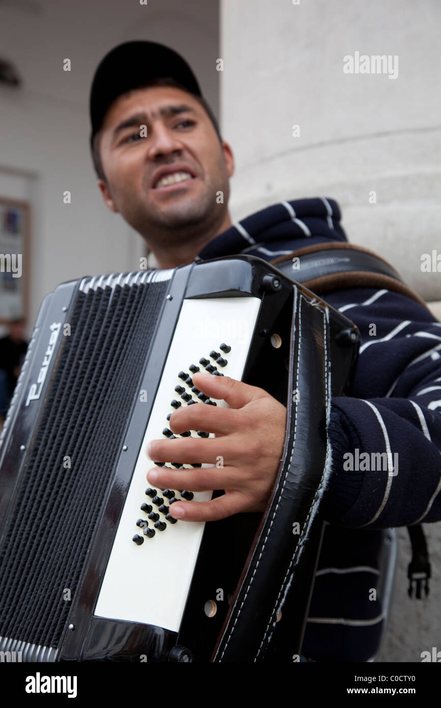 A busker plays an accordion in the street Stock Photo Alamy