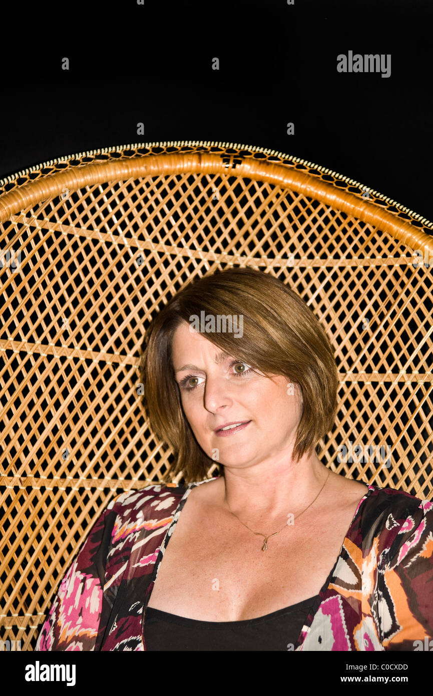 Studio portrait of beautiful middle aged attractive Mom with bright colored blouse on black