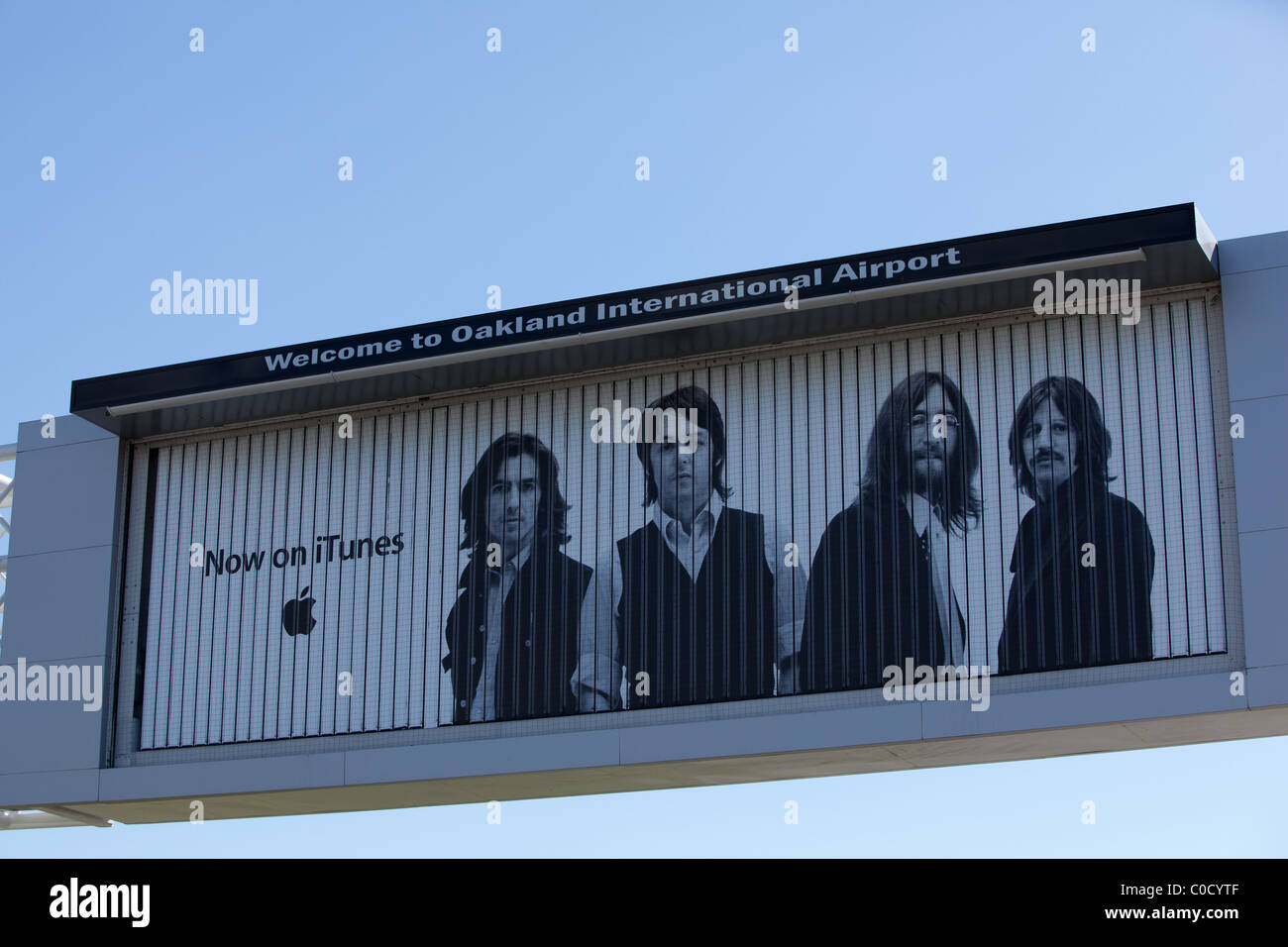 Oakland International Airport (OAK) sign, with iTunes Beatles ad. Stock Photo