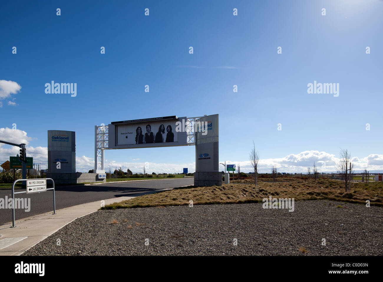 Oakland International Airport (OAK) sign, with iTunes Beatles ad. Stock Photo