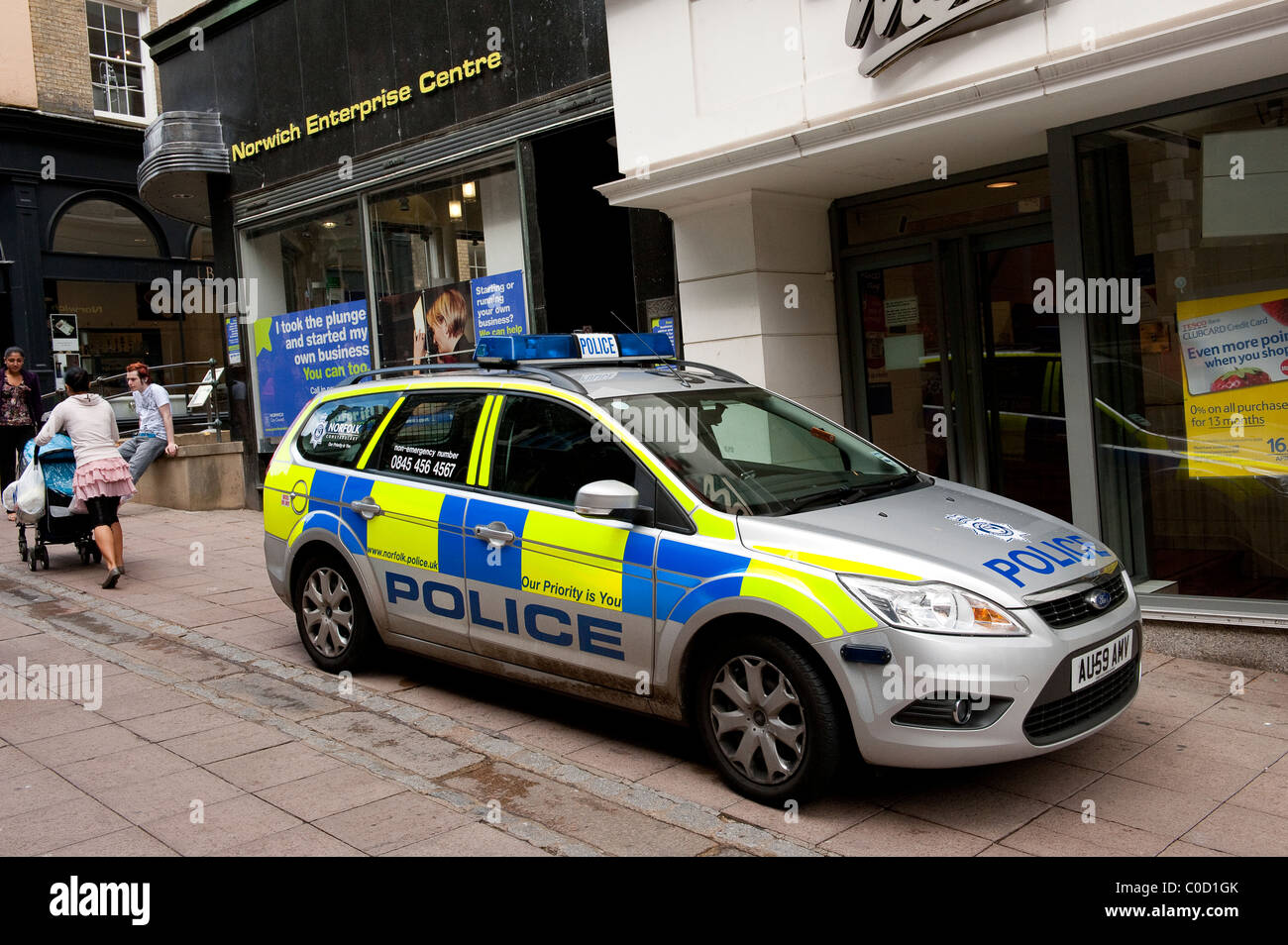 Silver police car parked outside shops on a street in Norwich, Norfolk ...