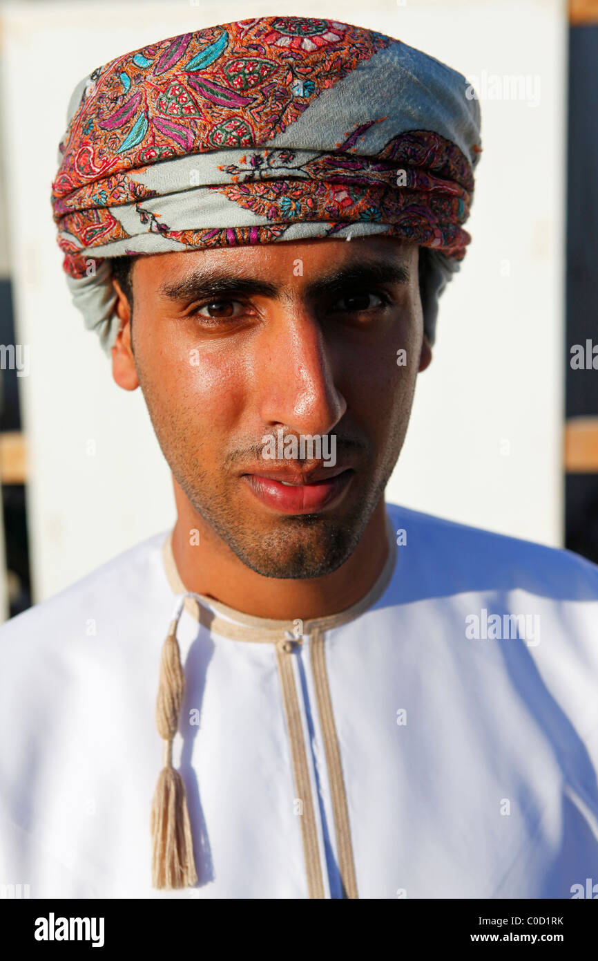 An Omani tour guide wears the national costume while leading a tour of Muscat, Oman Stock Photo 
