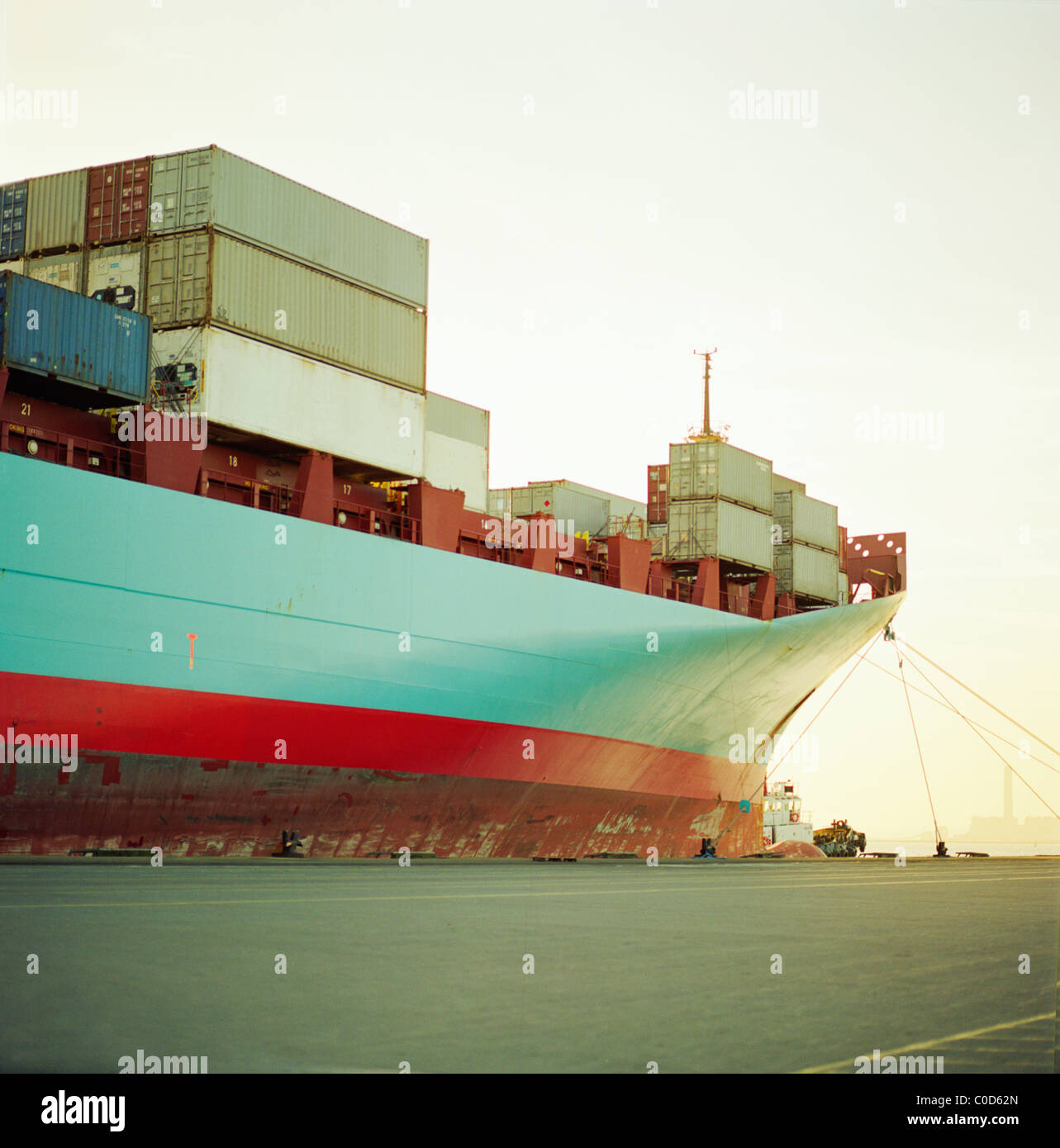 A container ship waiting at the quayside fully loaded Stock Photo