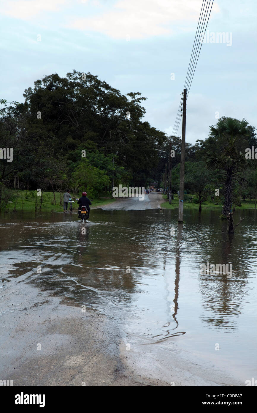 A  motorbike crosses a flooded road in the ancient city of Anuradhapura in North Central Sri Lanka Stock Photo