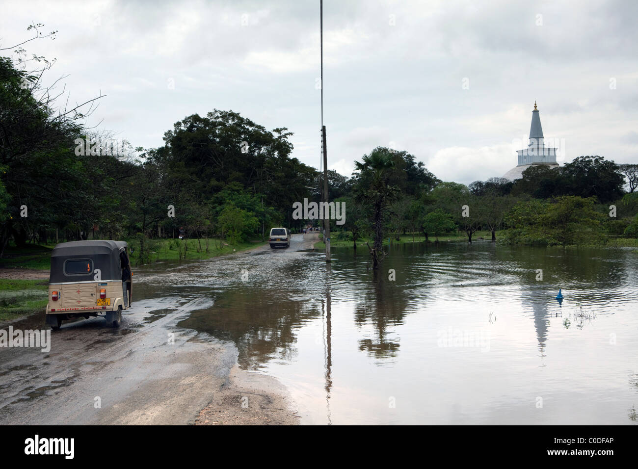 A tuk tuk crosses a flooded road in the ancient city of Anuradhapura in North Central Sri Lanka Stock Photo