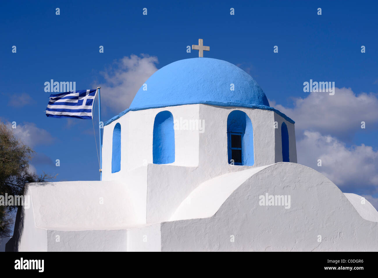 Orthodox church and Greek flag in Parikia, on the Greek Cyclade island of Paros. Stock Photo