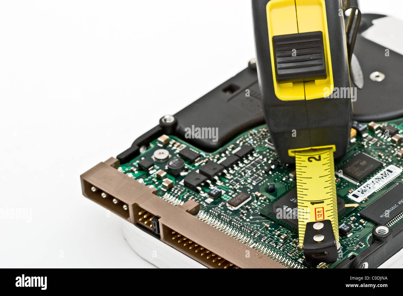 Yellow and black tape measure on a circuit board Stock Photo