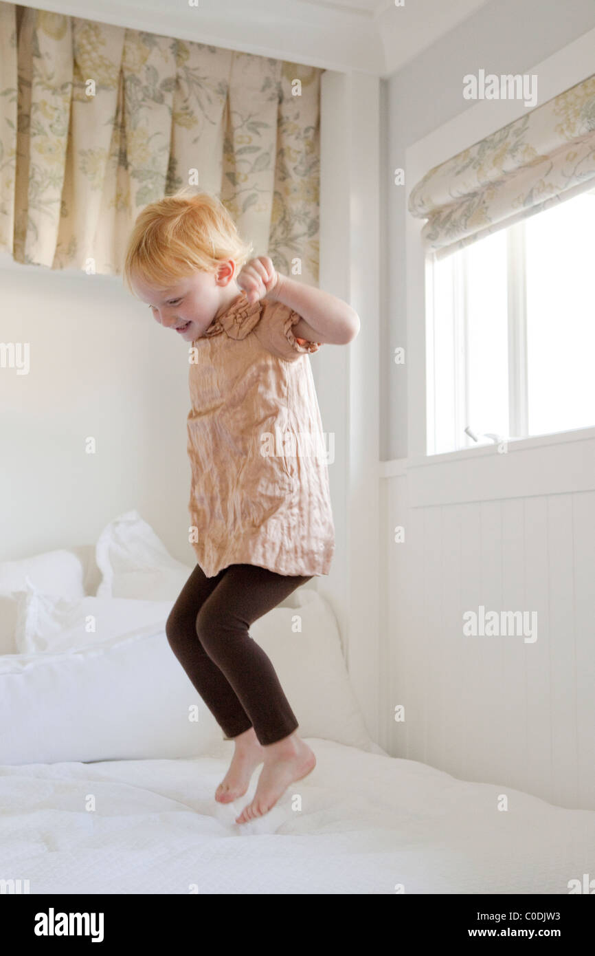 Little girl jumping on the bed Stock Photo