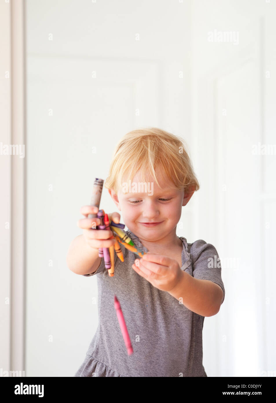 Little girl playing with crayons Stock Photo