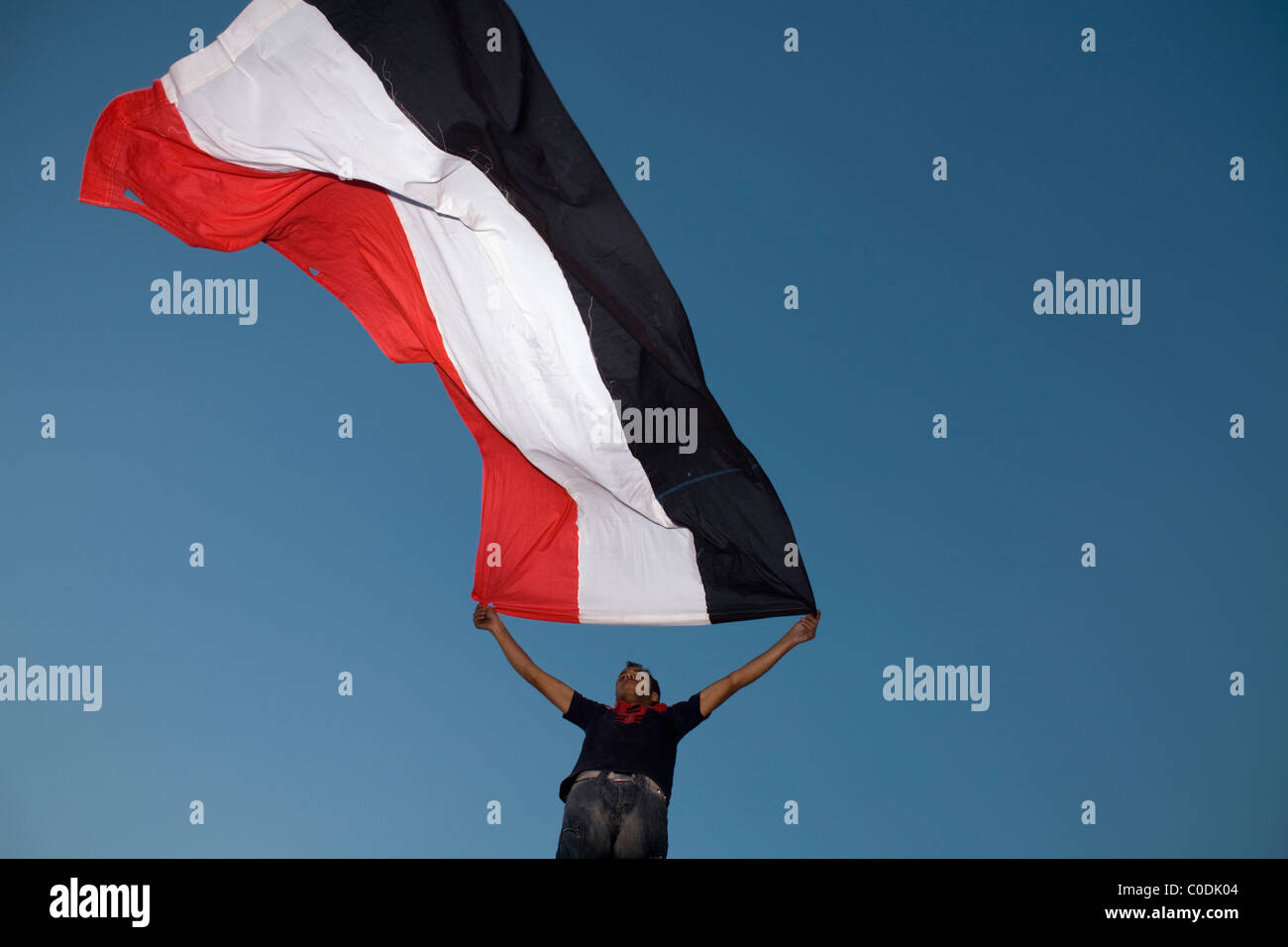 A man holds up an Egyptian flag during the anti-government protests in downtown Cairo's Tahrir Square on Jan.29, 2011 Stock Photo