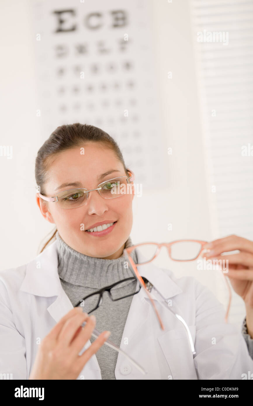 Optician doctor woman with prescription glasses and eye chart Stock Photo