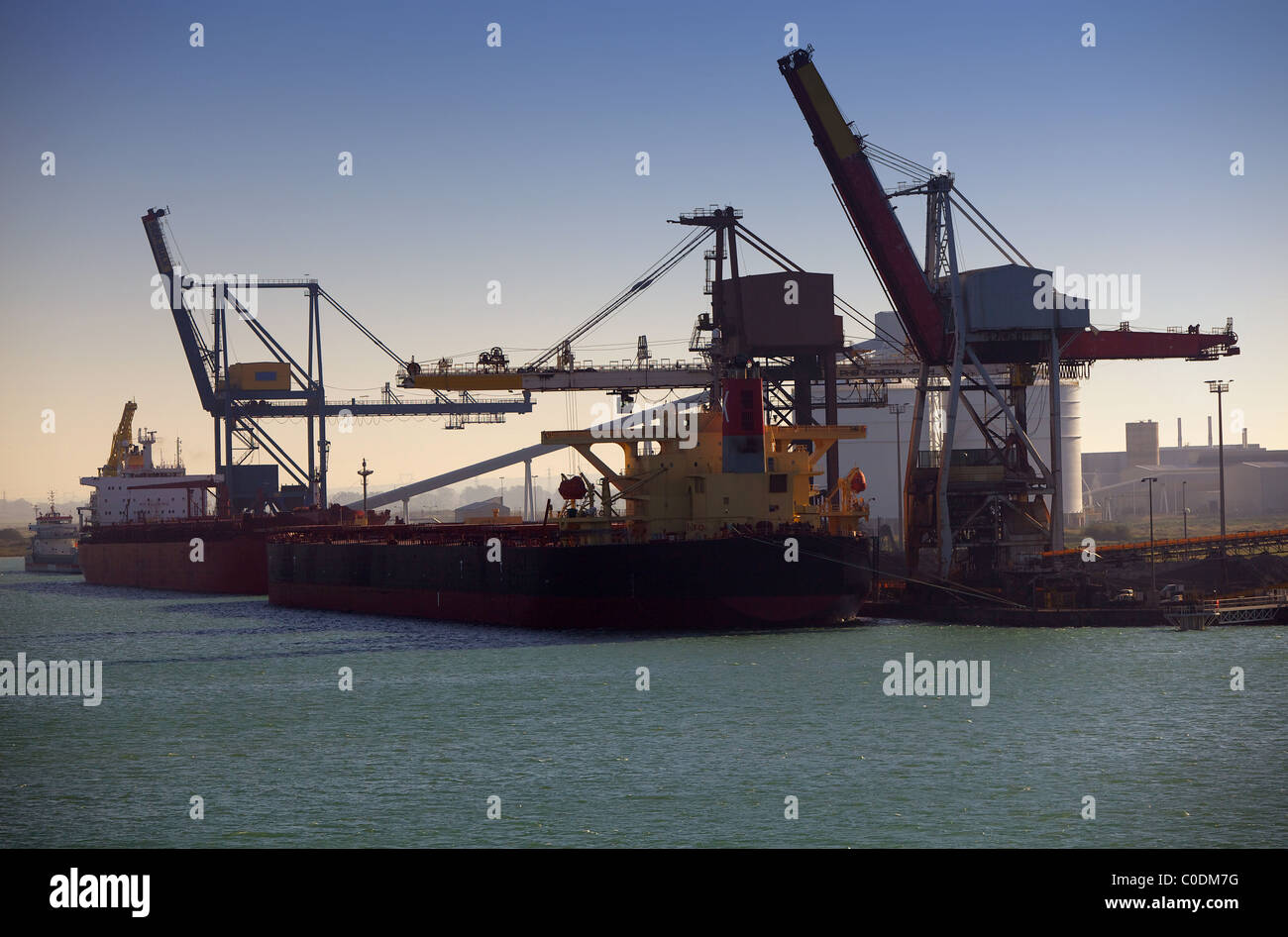 Cargo ships and tankers loading and unloading their cargos at an ...