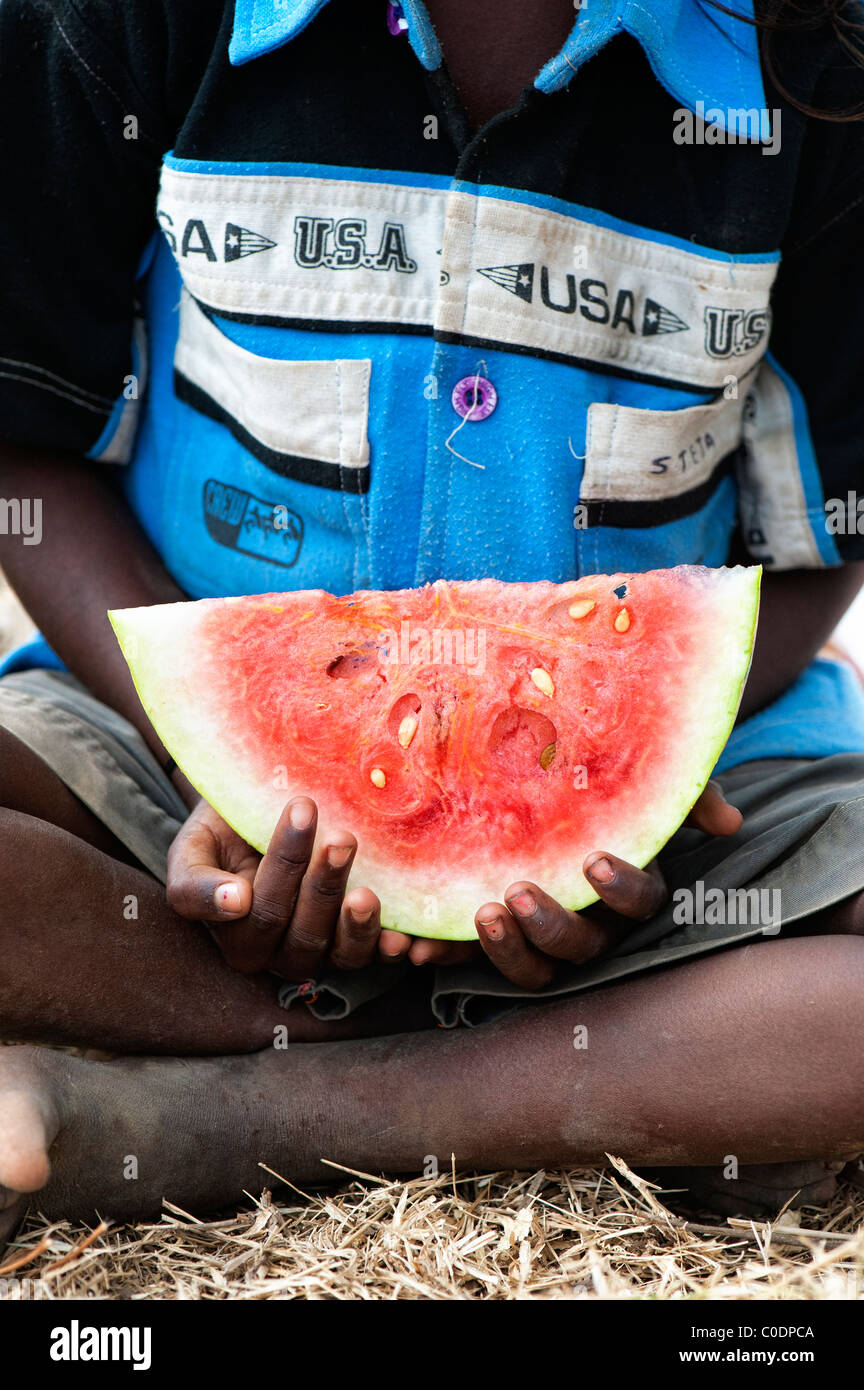 Young poor lower caste Indian street boy holding a slice of watermelon close up. Andhra Pradesh, India Stock Photo