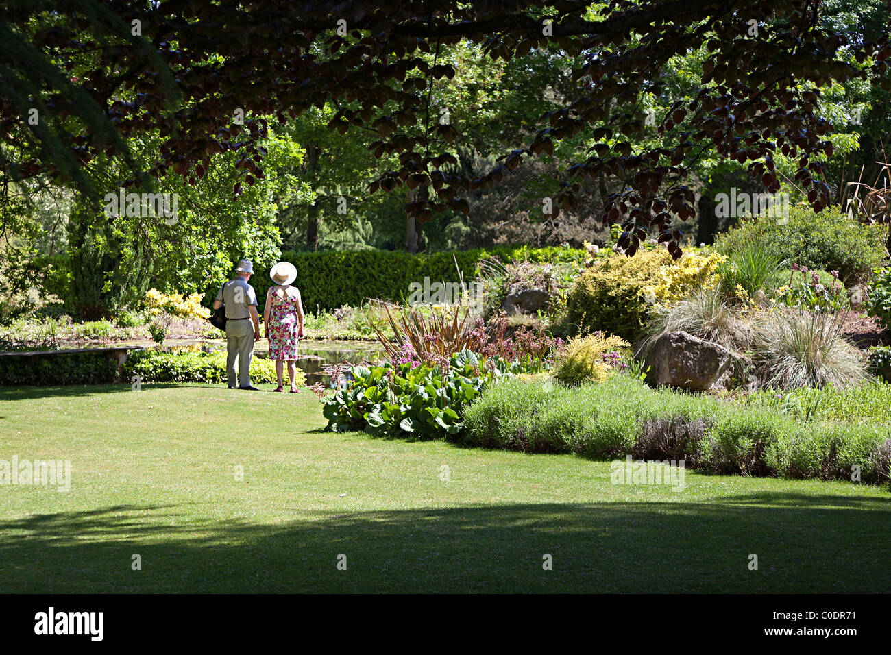 Two people near pond at Dewstow Gardens Wales UK Stock Photo