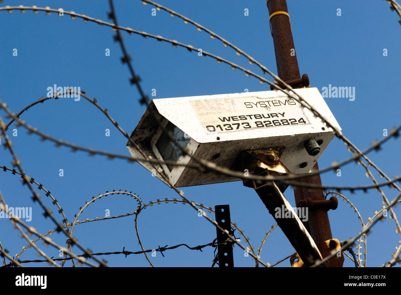 cctv security camera surrounded by razor wire against a blue sky Stock ...