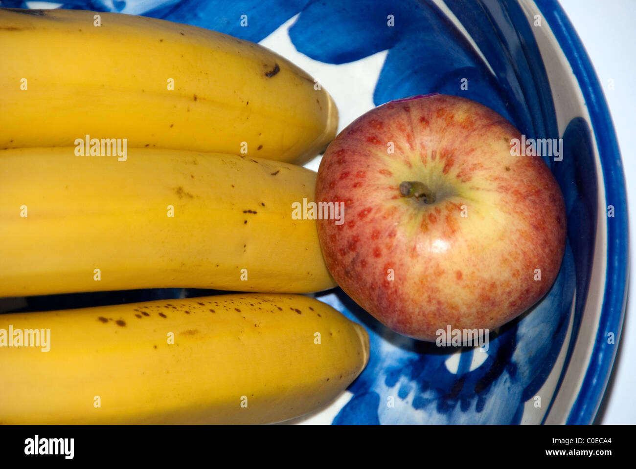 Bananas and apple in a bowl Stock Photo