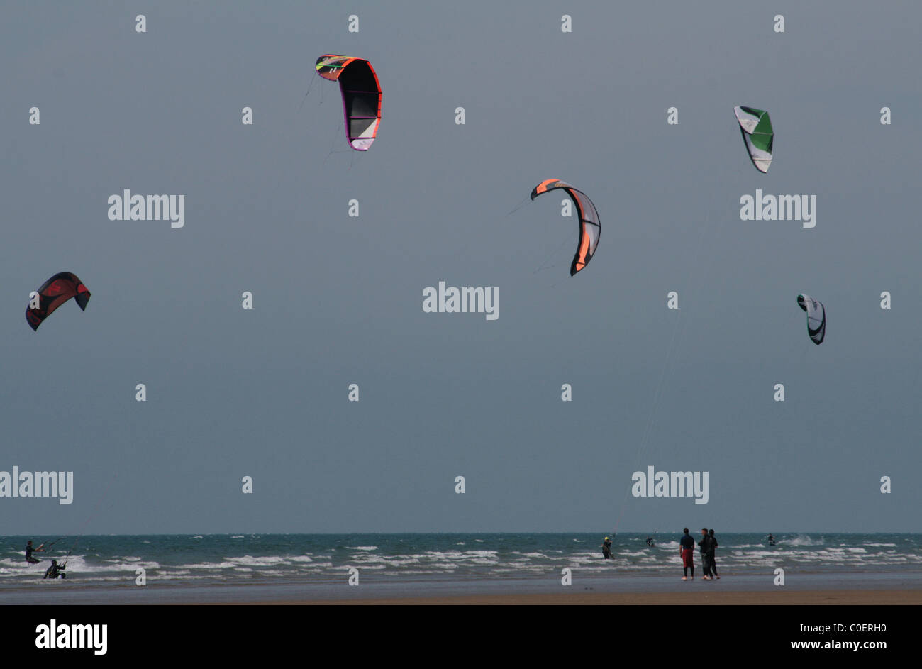 Kite Surfers with their Bright Kites Skimming the Waves at Westward Ho! Devon, U.K. Stock Photo